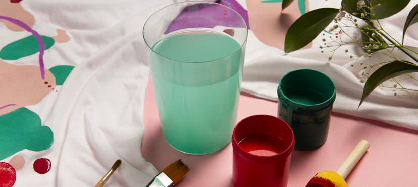 Enfant décorant un pot de fleurs avec de la gouache, plantant une fleur dans un pot décoré.