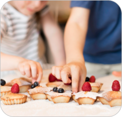 Enfant mesurant des ingrédients pour des muffins, décorant des muffins cuits.