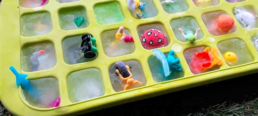 Enfant manipulant des cubes de glace pour découvrir des jouets à l'intérieur.