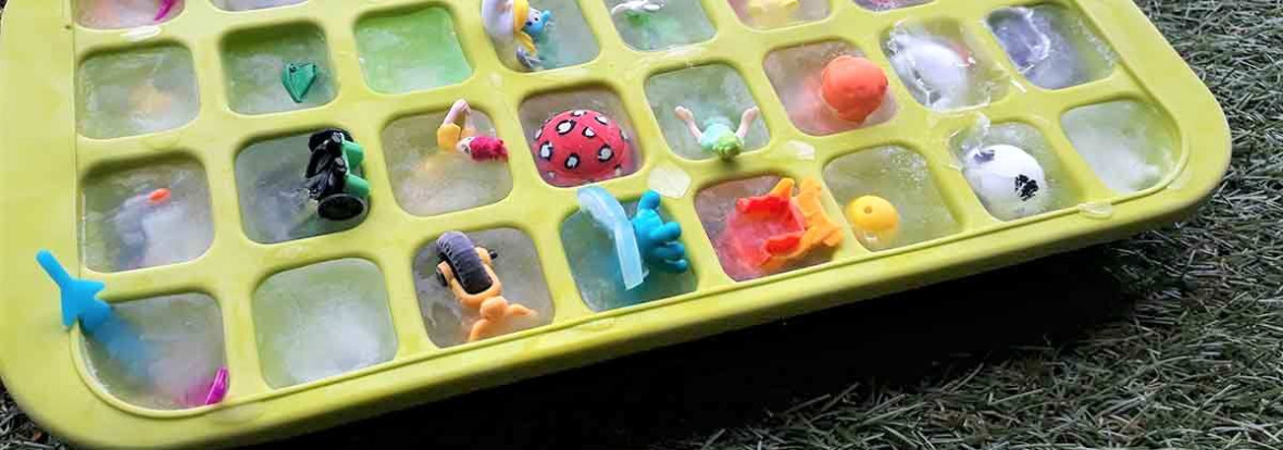 Enfant manipulant des cubes de glace pour découvrir des jouets à l'intérieur.