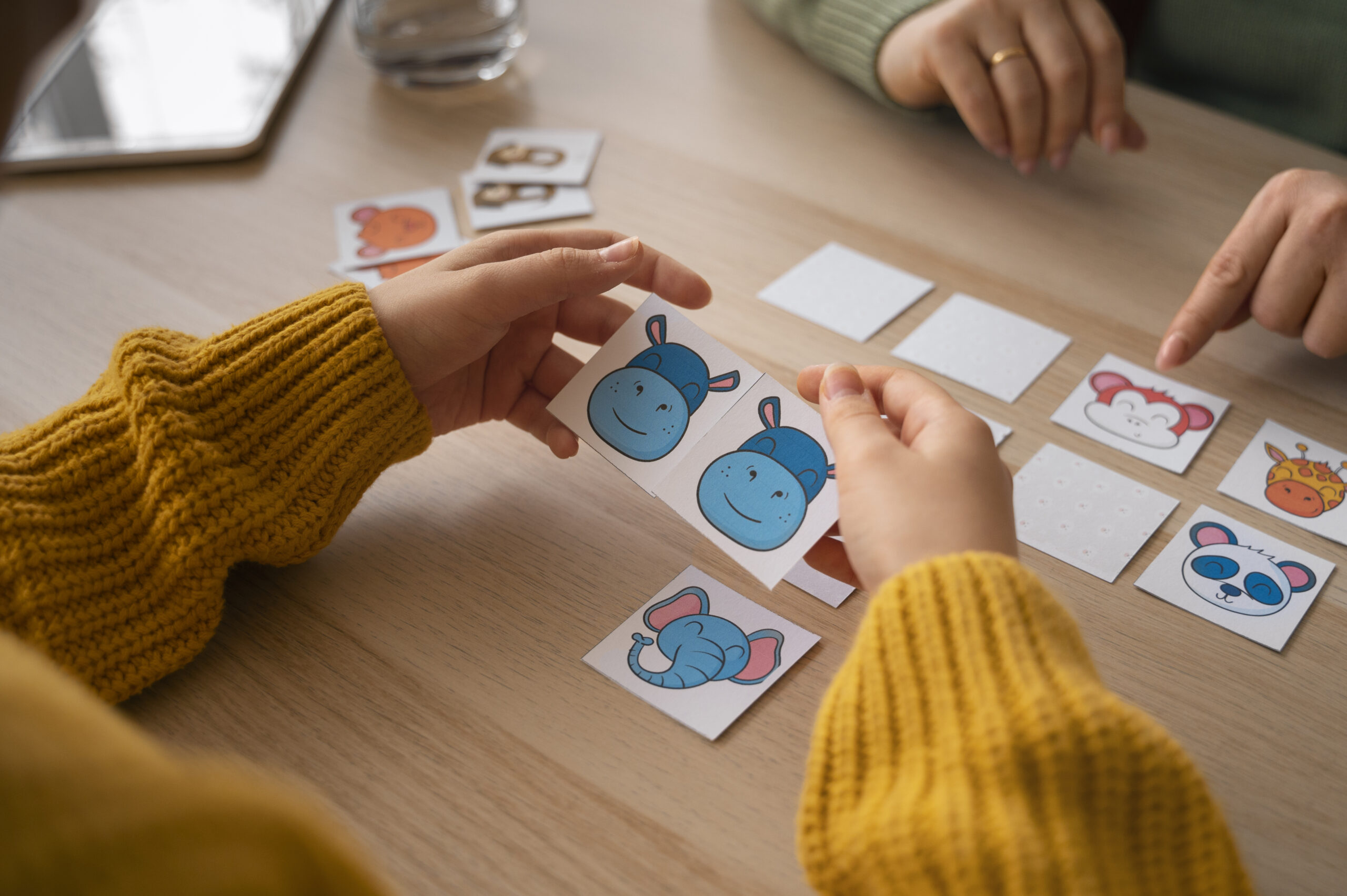 Enfants jouant à un jeu de rapidité avec des cartes d'animaux et d'objets.