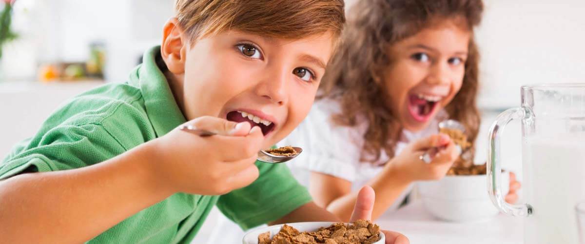 Enfant mangeant un repas équilibré avec des légumes, des fruits et des protéines, symbolisant l’importance de la nutrition pour les performances scolaires